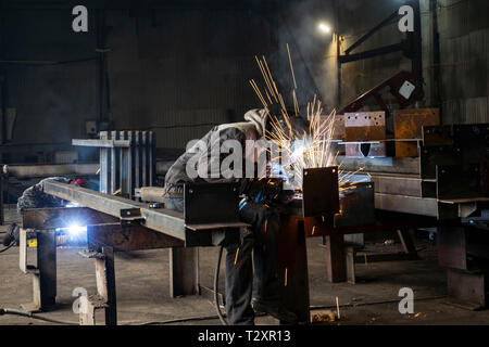 Welding with sparks by Process fluxed cored arc welding ,Industrial steel welder part in factory welder Industrial automotive part in factory Stock Photo