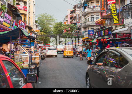 Phnom Penh, Cambodia - January 17, 2019: Street 136 (Oknha In St.) with its hostess bars, street food and diverse inhabitants in the sunset light. Stock Photo