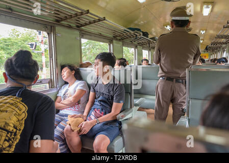 Bangkok, Thailand - August 18, 2018: passengers and a conductor in a third class car of a train Bangkok - Nam Tok. Stock Photo