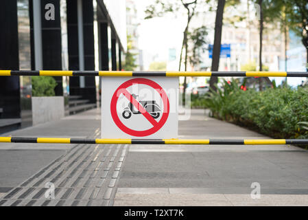 Sign 'No motorbikes' at sidewalk in the downtown of Ho Chi Minh City. Parking & driving scooters and motorcycles on sidewalks are habitual in Vietnam. Stock Photo