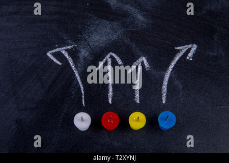 different pins on blackboard with arrows Stock Photo