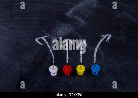 different pins on blackboard with arrows Stock Photo