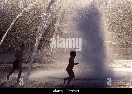 Salmon Street Springs fountain summer fun with young boys playing in fountain at sunset dusk Portland Oregon State USA Stock Photo