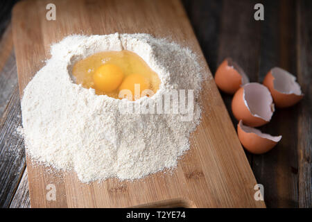Two eggs in flour with egg shells on the side. Stock Photo