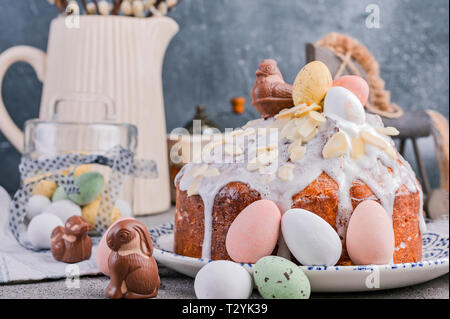 Easter orthodox sweet bread, kulich and colorful quail eggs with willow branches. Holidays breakfast concept with copy space. Retro style. Stock Photo