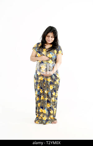 Pregnant woman touching belly. Isolated on the white background. Stock Photo