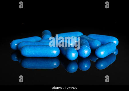 Lot of whole blue sweet licorice comfit isolated on black glass Stock Photo