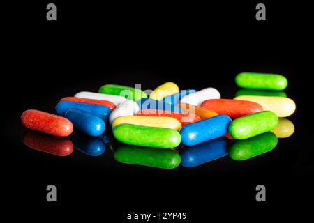 Lot of whole sweet licorice comfit isolated on black glass Stock Photo