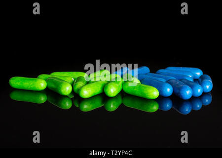 Lot of whole green and blue sweet licorice comfit isolated on black glass Stock Photo