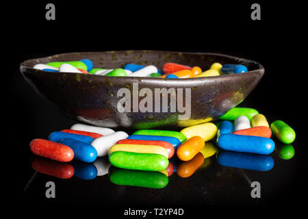 Lot of whole sweet licorice comfit isolated on black glass Stock Photo
