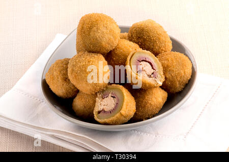 Olive ascolane, or deep fried breaded stuffed olives with meat filling from the Marche region of Italy served in a bowl with one cut through Stock Photo