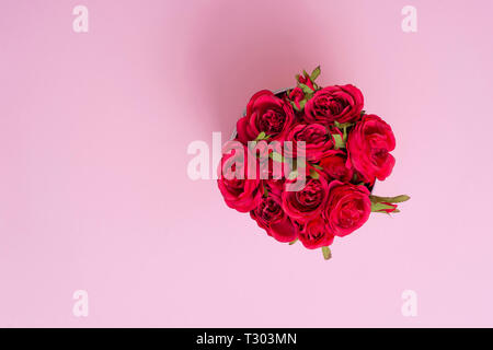 Beautiful red roses in a round box. Roses in a round box on a pink background. Roses in a Hat Box Stock Photo