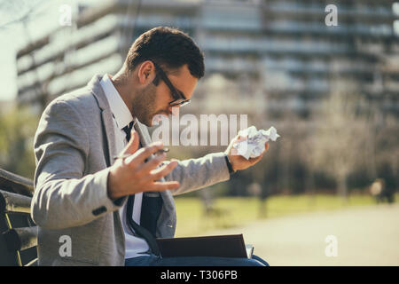 Young businessman is angry and overworked. Stock Photo