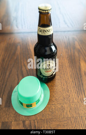 March 23 2019 - Calgary, Alberta Canada - Guinness Stout bottles with green hat - St Patrick's Day Concept Stock Photo