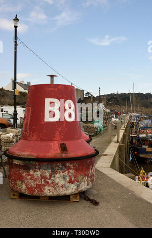 Red, port navigation buoy, lateral mark on quayside for maintenance Conwy harbour at low tide in Conwy north wales uk Stock Photo
