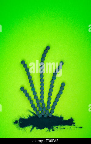 Spirulina tablets and powder in shape of algae. Green superfood, detox. Stock Photo