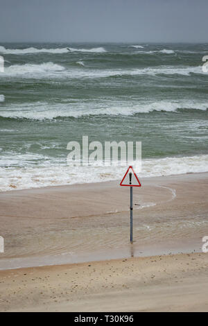 Stormy Baltic sea at Curionian Spit with warning sign. Stock Photo