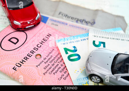 Old and topical German driving licences by miniature cars and bank notes, exchange costs for old driving licences, Alte und aktuelle deutsche Führersc Stock Photo