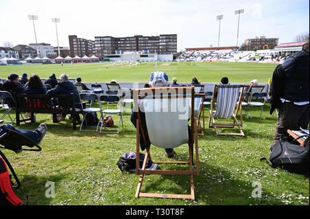 Hove Sussex, UK. 05th Apr, 2019. Spectators watch Sussex v Leicestershire in the Specasavers County Championship Division Two match at the 1st Central County Ground in Hove on a sunny but cool first morning of the season Credit: Simon Dack/Alamy Live News Stock Photo