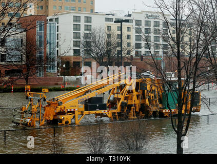 Davenport, Iowa, USA. 5th Apr, 2019. Canadian Pacific Railway employees run a railroad track tie replacement machine along a section of flooded track in LeClaire Park Thursday, April 4, 2019. Credit: Kevin E. Schmidt, Kschmidt@Qctim/Quad-City Times/ZUMA Wire/Alamy Live News Stock Photo