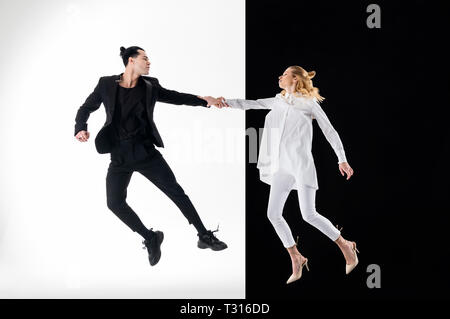 Jumping for shot. Professional young models in black and white clothing jumping for nice shot Stock Photo