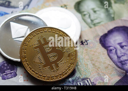 Bitcoin, Ethereum coins on Chinese Yuan banknotes. Close-up. Stock Photo