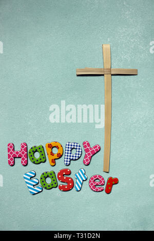 Colourful Letters saying Happy Easter with a Palm  Cross Stock Photo
