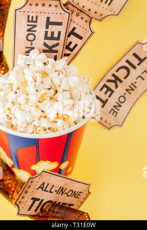 Movie tickets, film strips and popcorn on blue background. Copy space for text. Stock Photo