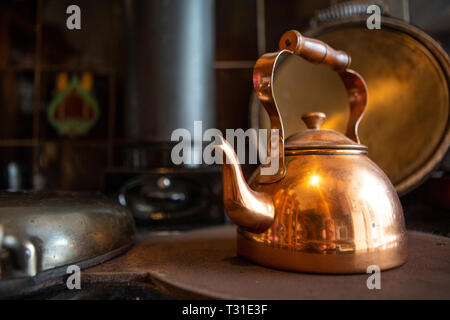 Copper kettle on stove Stock Photo