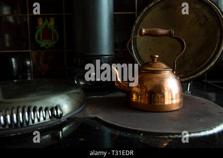 Copper kettle on stove Stock Photo