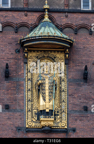 The ornate gilded copper statue of Bishop Absalon (the founder of Copenhagen in 1167) take pride of place above the entrance to Copenhagen Town Hall. Stock Photo