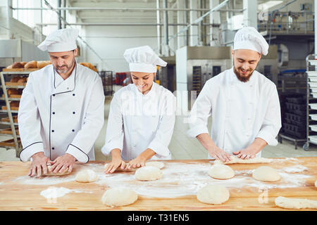 Bakers kneading dough in a bakery Stock Photo