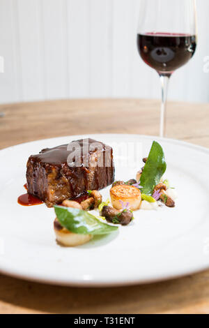 Beef brisket with mushrooms, sage and a glass of red wine Stock Photo