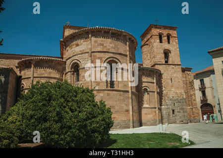 People walking next to Parish of St. Peter the Apostle at Avila. With an imposing wall around the gothic city center in Spain. Stock Photo