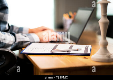 Survey form, customer satisfaction feedback poll, resume for job application or for college. Man writing with laptop.  Home or car insurance contract. Stock Photo