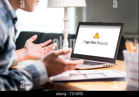 Page not found and error in laptop. Bad or slow internet connection. Frustrated man spreading hands in home office desk. Broken computer not working.  Stock Photo