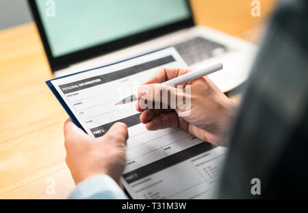Survey, agreement or application paper. Man writing personal information to questionnaire, contract or home insurance paper. Stock Photo