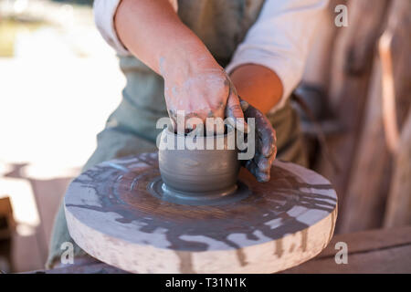Potter is creating earthenware on potter's wheel. Stock Photo