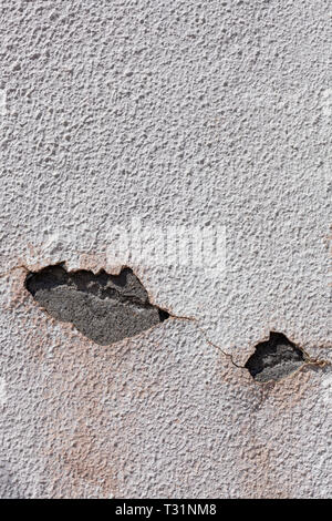 Wall with old paint and peeling, where you can see the cement through two holes open in the layer of paint. Can be used as background. Stock Photo