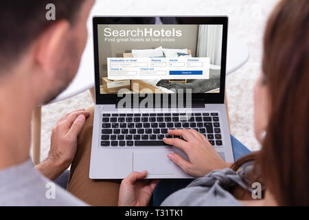 Close-up Of A Couple Searching Hotels With Low Prices On Laptop Stock Photo