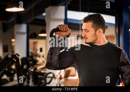 Attractive male athlete doing biceps exercise with dumbbell Stock Photo