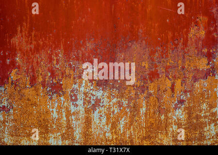 Texture of old rusty metal, painted red which becames orange from rust. Horizontal texture of cracks and peels paint on rusty steel Stock Photo