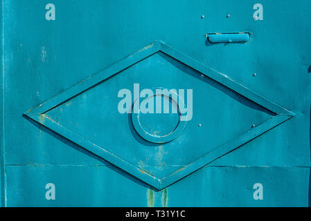 Texture of old rusty metal, painted light-blue with rombus from metal tape in the centre. Horizontal texture of cracked paint on rusty steel Stock Photo