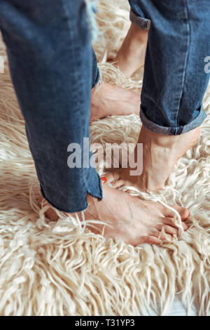 cropped view of man and woman standing on carpet in bedroom Stock Photo