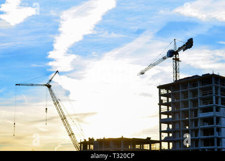 Cranes and construction site on the background of sunset and beautiful sky Stock Photo