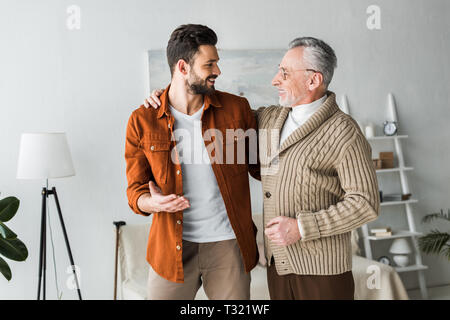 handsome man gesturing and looking at cheerful senior father Stock Photo