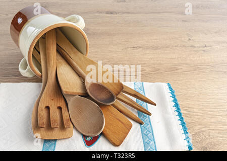 posate di legno dentro vaso di coccio rovesciato e tovagliolo Stock Photo