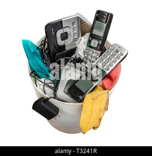 Horizontal shot of land line telephones thrown away in a trashcan.  This shot is looking down on the trashcan. Stock Photo