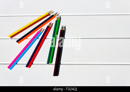 Colored pencils aligned on white pallet table Stock Photo