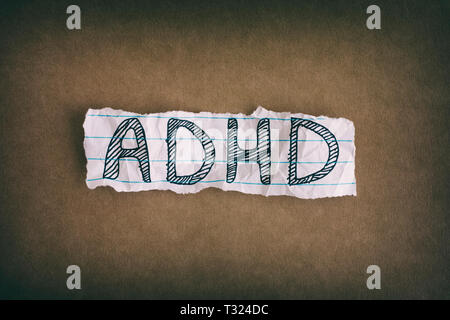 ADHD. Abbreviation ADHD on brown background. Close up. ADHD is Attention deficit hyperactivity disorder. Stock Photo